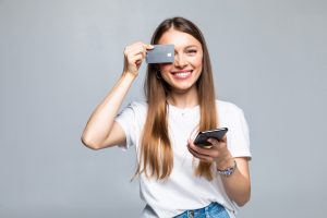 Cheerful Excited Young Woman With Mobile Phone Credit Card 1 Scaled